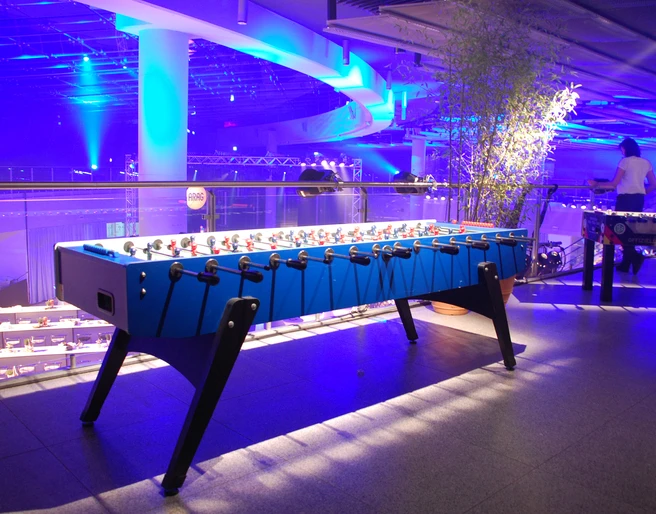Riesentischkicker 01 Ein beleuchteter Tischfußballtisch in modernem, blauem Design in einer stimmungsvoll blauen Umgebung.An illuminated table football table in a modern, blue design in an atmospheric blue setting.