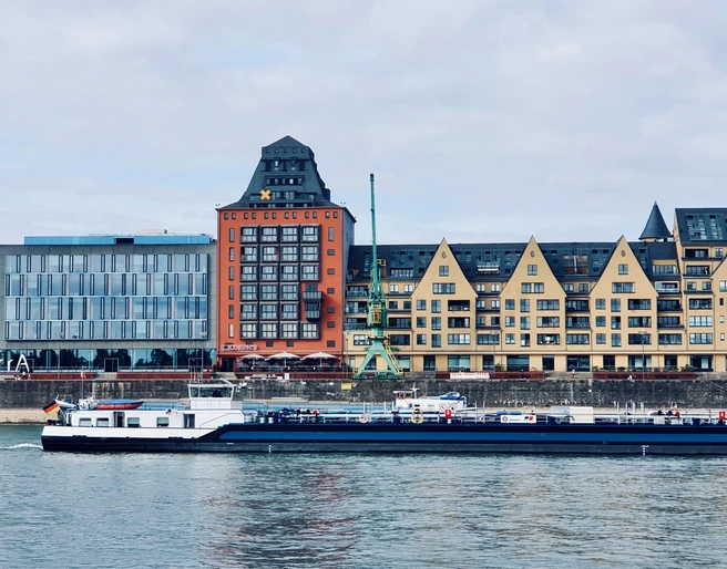 1_Intercom_START.png.jpg <p>Frachtschiff fährt vor Kölner Rheinauhafen mit modernen Gebäuden und charakteristischen Dächern.</p><p>Cargo ship sails in front of Cologne's Rheinauhafen with modern buildings and characteristic roofs.</p>
