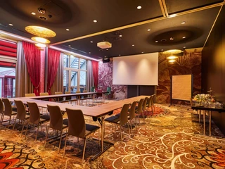 Attila, Gerasina U-Form.jpg <p>Tagungsraum mit U-förmiger Tischanordnung, Projektionsleinwand, Flipchart und eleganter Beleuchtung.</p><p>Meeting room with U-shaped table arrangement, projection screen, flipchart and elegant lighting.</p>