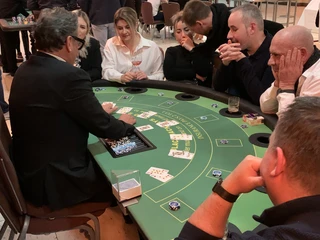 Black Jack 02 Pokertisch mit spielenden Menschen, Karten und Chips im Casino-ähnlicher Atmosphäre.Poker table with people playing, cards and chips in a casino-like atmosphere.
