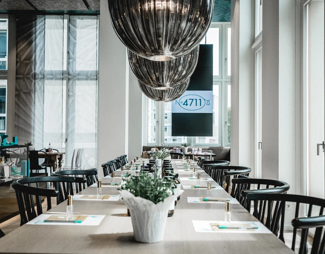4711 Duftseminar Modernes Restaurant mit langen Tischen, stilvollen schwarzen Stühlen und eleganten Deckenlampen.</p>Modern restaurant with long tables, stylish black chairs and elegant ceiling lamps.</p> <p