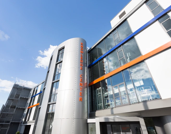 GS1 Germany GmbH - Knowledge Center  Moderne Fassade eines Gebäudes mit der Aufschrift "Knowledge Center" unter blauem Himmel.</p>Modern facade of a building with the inscription "Knowledge Center" under a blue sky.</p> <p