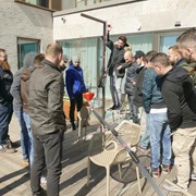 Kugelbahn_Hauptmotiv.jpg Eine Gruppe von Männern baut gemeinsam eine kreative Konstruktion auf einer Holzterrasse.A group of men work together to build a creative construction on a wooden terrace.