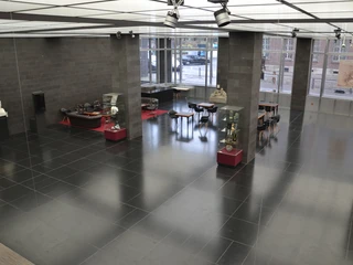 Foyer - Blick aus dem Seminarraum.JPG Geräumiger Ausstellungsraum mit modernen Skulpturen auf schwarzen, glänzenden Bodenfliesen.</p>Spacious showroom with modern sculptures on glossy black floor tiles.</p> <p