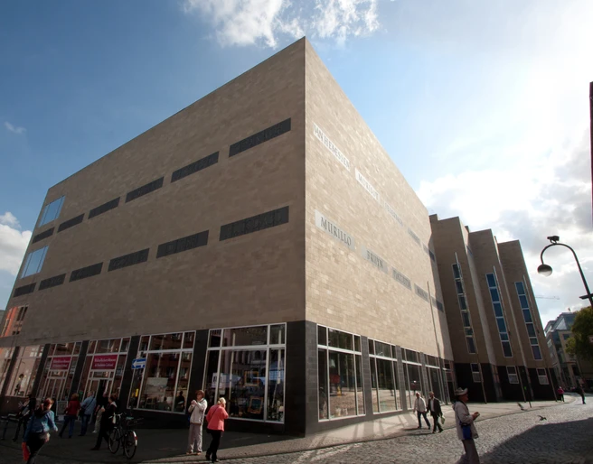 Außenansicht Wallraf ohne Banner_ (c) by C.Quester Kopie.jpg Ein modernes Museum mit sandfarbenen Fassaden, großen Glasfenstern und Fußgängern davor.Exterior view of the Wallraf-Richartz Museum