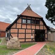 Ole Schüne Drakenburg Fachwerkgebäude in Drakenburg mit rotem Ziegeldach, umgeben von Bäumen und Wiesen, historisches Flair.