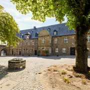 Schloß Broich, Mülheim an der Ruhr  <p>Historischer Innenhof mit Brunnen, von Bäumen umgeben und mit Steinpflaster ausgelegt.</p>