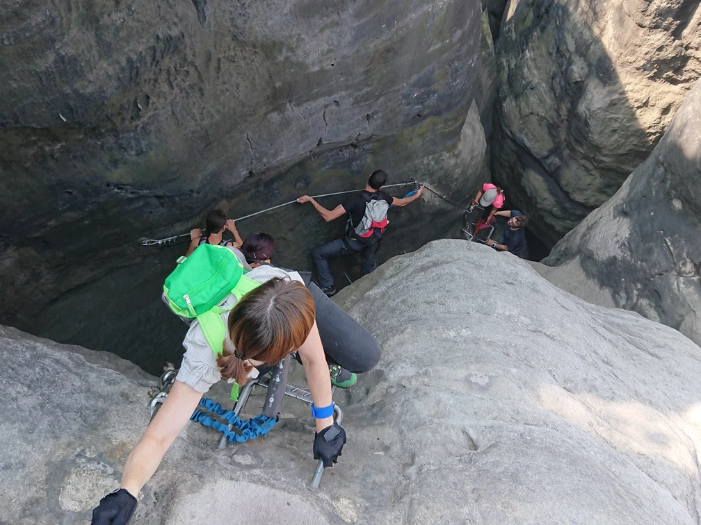 DSC_8632.JPG Abenteuerlustige erklimmen felsige Klippen, gesichert mit Drahtseilen in einer beeindruckenden Schlucht.
