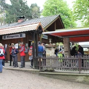 Dörenther Klippen_Almhütte_Teutoburger Wald Tourismus.JPG Eine Gruppe Wanderer versammelt sich vor einer Almhütte mit Biergarten im Teutoburger Wald.