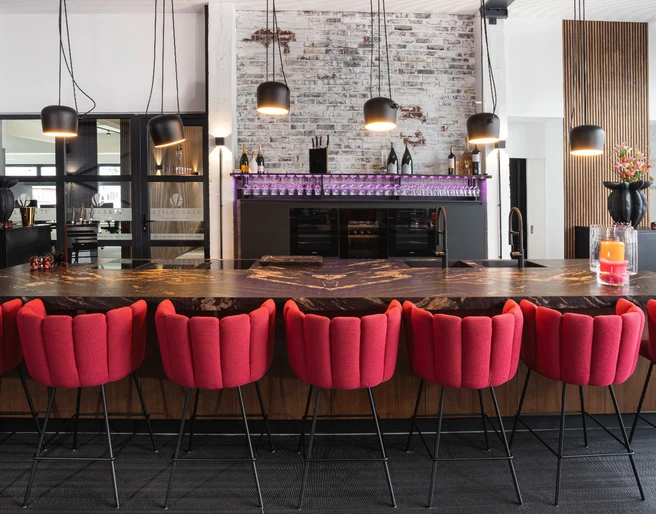 Interieur Moderner, heller Eventraum mit länglichen Tisch in der Mitte und roten StühleModern, bright event room with an elongated table in the middle and red chairs