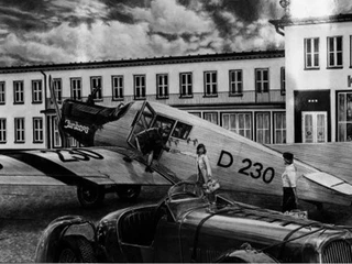 Vor der historischen Empfangshalle  Alte Schwarz-Weiß Aufnahme von einem Flugzeug auf dem Butzweiler Hof, Zwei Frauen stehen am FlugzeugOld black and white photo of an airplane at the Butzweiler Hof, two women standing by the plane