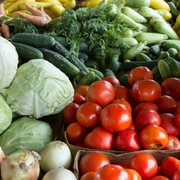 bad-driburg_wochenmarkt_pexels.jpg Frisches Gemüse mit Tomaten, Kohl, Zucchini und Möhren auf einem belebten Marktstand ausgebreitet.