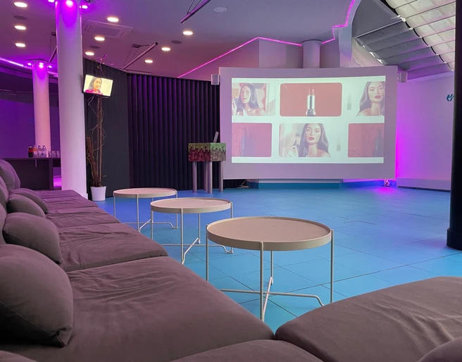 Tagung Ein großes Sofa steht vor einer großen LeinwandA large sofa stands in front of a large screen.