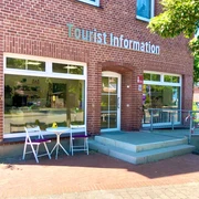 Tourist information Ein rotes Backsteingebäude mit der Aufschrift "Tourist Information". Ein Tisch und zwei Stühle stehen vor dem Eingang.A red brick building with the inscription "Tourist Information". A table and two chairs stand in front of the entrance.