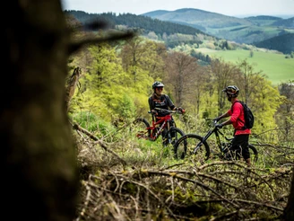 Mountainbiker-Paar im Gelände vor Bergpanorama Mountainbiker-Paar im Gelände vor Bergpanorama