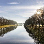 Decksteiner Pond Der Decksteiner Weiher in Köln, umgeben von sonnenbeschienenen Winterbäumen, reflektiert das klare Himmelblau.The Decksteiner Weiher in Cologne, surrounded by sunlit winter trees, reflects the clear blue sky.