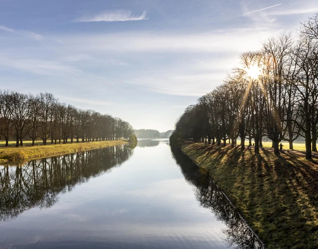 Decksteiner Pond Der Decksteiner Weiher in Köln, umgeben von sonnenbeschienenen Winterbäumen, reflektiert das klare Himmelblau.The Decksteiner Weiher in Cologne, surrounded by sunlit winter trees, reflects the clear blue sky.