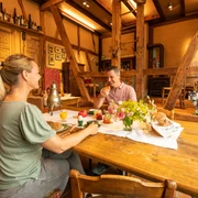 Ferienwohnung Hof Tüschenbonnen <p>Ein Paar genießt Frühstück an einem rustikalen Holztisch mit Gebäck und Blumen in gemütlicher Atmosphäre.</p>