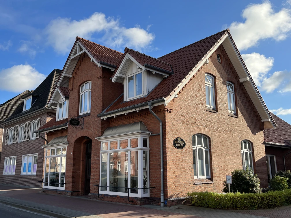 Aussenansicht des Fehntjer Forum IMG_1331.JPG Schönes Gebäude mit rotem Klinker - Fehntjer Forum am Untenende mit strahlendem Sonnenschein und Schäfchenwolken in der Gemeinde Rhauderfehn