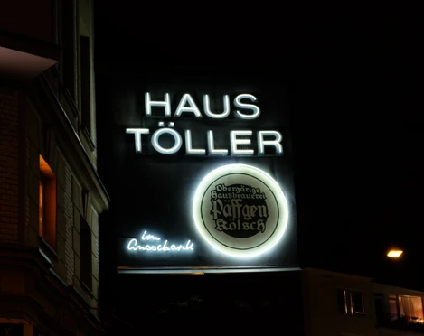 House Töller neon Neonbeleuchtetes Schild des "Haus Töller" bei Nacht mit dem Logo der Brauerei Päffgen Kölsch.Neon-illuminated sign of "Haus Töller" at night with the logo of the Päffgen Kölsch brewery.