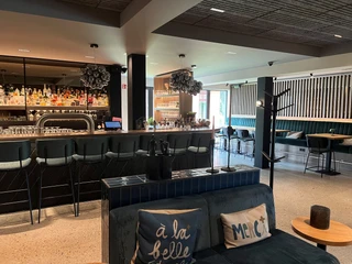 Eine elegante Bar mit modernen Sitzgelegenheiten, dekorativen Lampen und gut sortierten Flaschen.