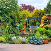 IMG-20240525-WA0016.jpg Ein liebevoll angelegter Garten mit üppiger Pflanzenpracht und einer einladenden Sitzbank am Teich.