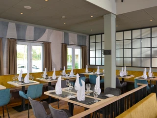 Restaurant im Sure Hotel by Best Western Hilden-Düsseldorf Ein helles Restaurant mit modernen Möbeln, gedeckten Tischen und großen Fenstern für viel Tageslicht.