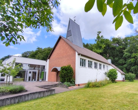 Die evangelische Johanneskirche in Hövelhof vereint moderne und traditionelle Architektur umgeben von Grün.