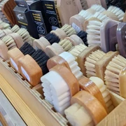 Eine Nahaufnahme handgefertigter Bürsten in verschiedenen Formen und Farben auf einem Marktstand.