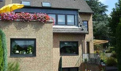 Haus Panorama in Ratingen Modernes zweistöckiges Einfamilienhaus in Ratingen mit Klinkerfassade, bepflanztem Balkon und Garten.
