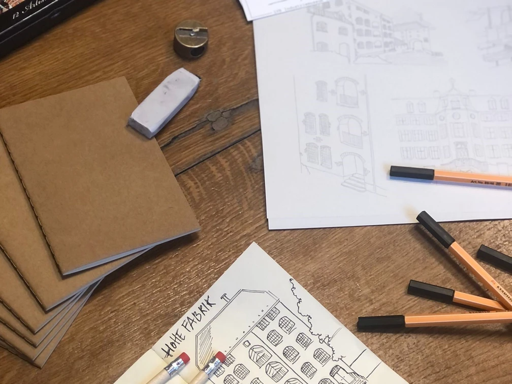 Cromforder Scribble Book Skizzen und Zeichenmaterial am Holztisch; Fokus auf architektonische Darstellungen historischer Gebäude.