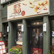 China Fortuna Haus Haupteingang zum Restaurant, darüber ein auffallend großes Schild mit Restaurantnamen und Floralen Details. Main entrance to the restaurant, with a remarkable large sign above it with the restaurant name and floral details.