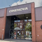 Cinenova Das Kino Cinenova befindet sich in einem roten Backsteingebäude mit einer modernen Glasfront, verziert mit kunstvollen Illustrationen. The Cinenova cinema is located in a red brick building with a modern glass facade adorned with artistic illustrations.