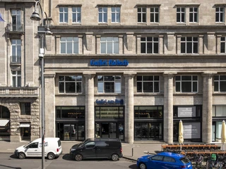 Gaffel am Dom Totale von der Hausfassade. Parkende Autos stehen vor dem Gebäude.Long shot of the building facade. Cars are parked in front of the building.