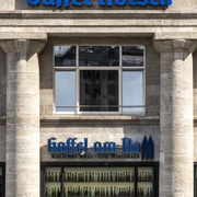 Gaffel am Dom Außenansicht auf das Brauhaus. Zwei markante Säulen rahmen ein Fenster ein, das mit bunten Flaschen dekoriert ist.Exterior view of the brewery. Two prominent columns frame a window decorated with colorful bottles.
