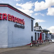 Herbrand's Hausfassade mit der Aufschrift Herbrands in großen roten Buchstaben.House front with the inscription Herbrands in large red letters.