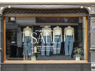 Keep Loving Schaufenster eines Geschäfts mit der Botschaft "Keep Loving. Move out. Sale. Store window of a store with the message "Keep Loving. Move out. Sale.