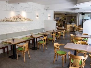 Oshos Place Im modernen Café Sierra mit Holzmöbeln und heller Wanddekoration herrscht eine einladende Atmosphäre.The modern Café Sierra, with its wooden furniture and bright wall decorations, has a welcoming atmosphere.