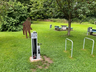 Rastplatz Petershagen Rastplatz mit Fahrradservice-Station, Tischgruppe und Wald im Hintergrund, ideal für Radfahrer.