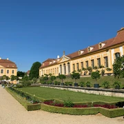 Barockgarten Großsedlitz Gebäude des Barockgarten Großsedlitz, im Vordergrund Rasen, Beete und Bäume, bei Sonnenschein.