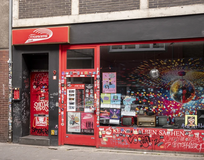 Tsunami Club Die Fassade des Tsunami Clubs im urbanen Stil, übersät mit Street Art und Plakaten.The façade of the Tsunami Club in urban style, littered with street art and posters.