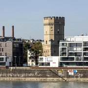 Bayenturm Der historische Bayenturm erhebt sich eindrucksvoll am Rhein, umgeben von moderner Architektur.The historic Bayenturm tower rises impressively on the Rhine, surrounded by modern architecture.