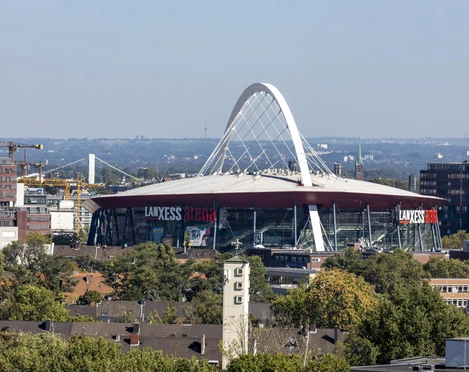 Lanxess Arena Lanxess Arena, ein riesiger roter Kuppelbau mit markantem weißen Bogenträger in Köln.Lanxess Arena, a huge red domed building with a striking white arched girder in Cologne.