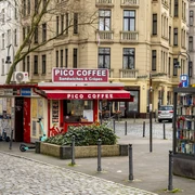 Pico Coffee Ein kleiner Kiosk mit rotem Schild und der Aufschrift "Pico Coffee" für Snacks und Getränke.A small kiosk with a red sign and the words "Pico Coffee" for snacks and drinks.