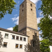 Luther Church Hohes, steinernes Kirchenturmgebäude, quadratisch, umgeben von modernen Gebäuden und Bäumen.High, stone church tower building, square, surrounded by modern buildings and trees.