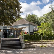 Cafe Friedolin BuezE Verzierte Terrasse mit Wimpelgirlande vor dem Bürgerzentrum Ehrenfeld mit umliegendem Park. Decorated terrace with a festive garland in front of the Ehrenfeld community center with a park around it.