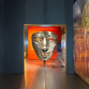 Varusschlacht im Osnabrücker Land - Museum und Park Kalkriese Große silberne Maske im Varusschlacht-Museum mit Besucher im Flur.