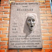 Gedenktafel am Hövelhof Bahnhof mit Relief eines schreienden Gesichts erinnert an Kriegsgefangene.