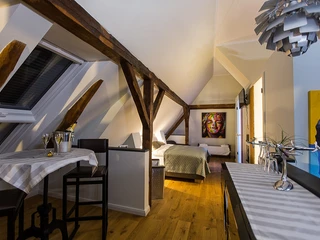 Soul Place John F. Kennedy  Gemütliches Loft mit schrägem Holzbalken, stilvoller Kunst an den Wänden und einem Dachfenster.