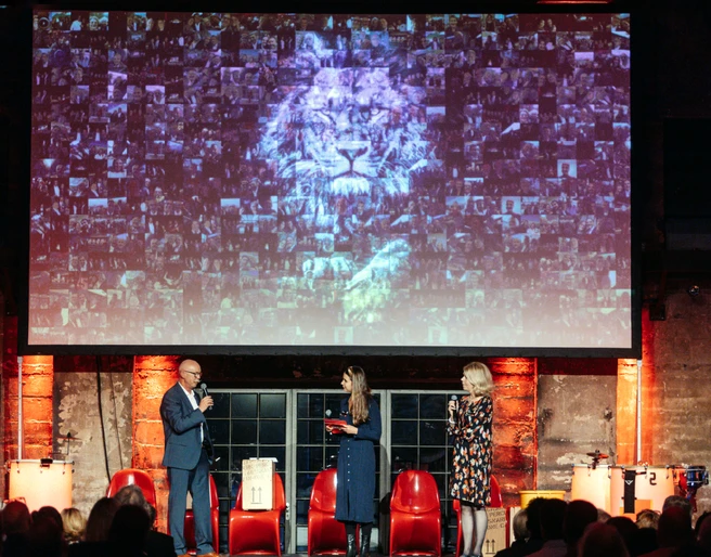 Großartige Präsentation – Business-Event mit beeindruckender Visualisierung 3 Personen stehen auf der Bühne vor einer großen Leinwand und halten eine Rede Three people are standing on the stage in front of a large screen and giving a speech.